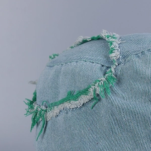 Denim bucket hat with distressed frayed edges and embroidered detail for street style