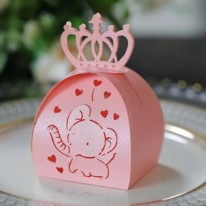 Close-up of pink laser-cut candy box with hollow elephant and heart pattern with crown handle