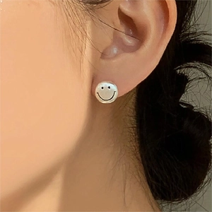 Minimalist 925 sterling silver smiley face stud earrings worn on female earlobe