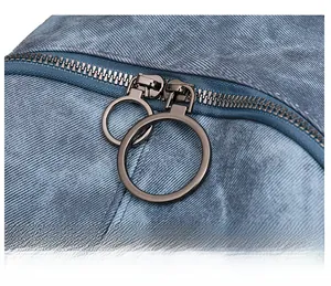Detail of blue twill fabric and large round metal ring double zippers on a stylish backpack