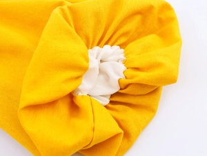 Detailed close-up of yellow puff sleeve fabric showing elastic hem and white inner lining