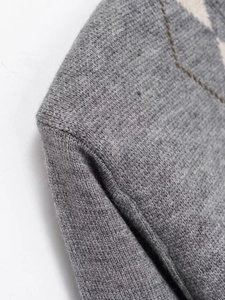 Close-up of high-quality grey knit cardigan featuring classic argyle diamond pattern