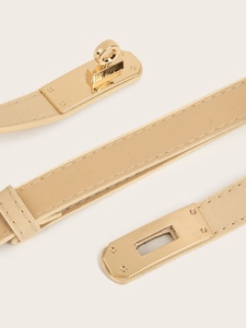 Close-up of beige leather belt with a polished gold turn-lock buckle and fine stitching