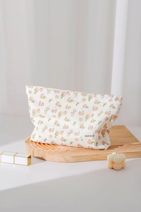 Floral cotton makeup bag with orange flower patterns on a wooden display stand