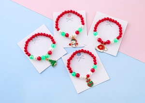 Detail of Christmas beaded bracelets with snowman, tree, and Santa hat charms for kids