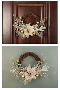 Detail of Christmas wreath with golden flowers, pine needles and snow on dark vine base