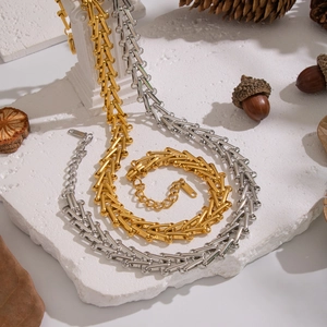 Detail view of gold and silver stainless steel geometric stair chain necklaces