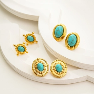Detailed view of three pairs of vintage 18K gold earrings with oval turquoise inlays