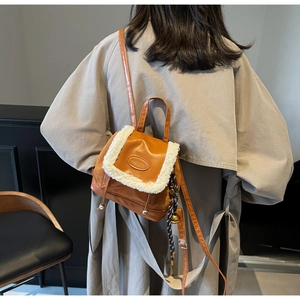 Détail du mini sac à dos en cuir PU marron avec bordure en fausse fourrure blanche sur le rabat