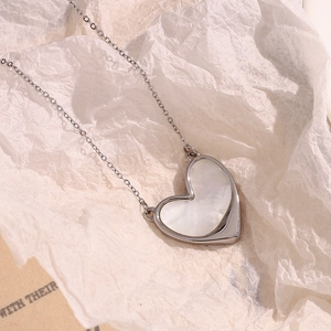 Macro detail of heart-shaped pendant with natural mother of pearl inlay on silver chain