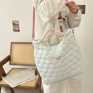 Détail du sac fourre-tout matelassé vert menthe avec poignées en corde et étiquette de marque