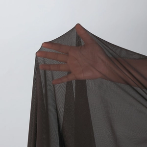 Close-up of semi-transparent dark brown mesh fabric showing fine texture and elasticity