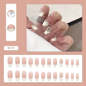 Detail of French tip press-on nails with 3D heart diamonds and nude pink base N5119