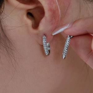 Silver U-shaped earrings with rhinestones on female model in 18k gold plated steel