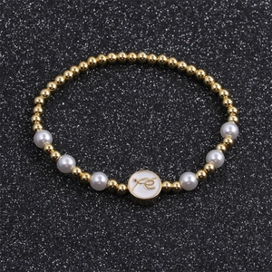 Elegantes vergoldetes Perlenarmband mit weißen Perlen und rundem Fé-Glaubensanhänger