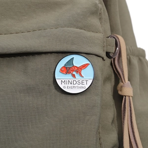 Close-up of koi fish enamel pin with 'Mindset is Everything' text on a canvas bag