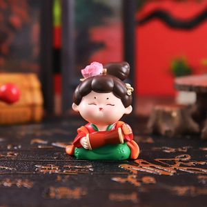 Traditional Chinese girl tumbler figurine in red and green attire playing waist drum