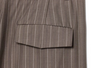 Gros plan sur le tissu rayé marron montrant la texture tissée et les détails de la couture