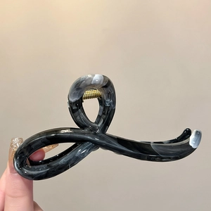 Detailed macro of the marbled acrylic hair claw clip with golden metal spring