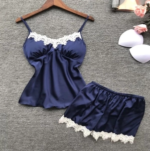 Detail of navy satin sleepwear set showing delicate white lace trim and silky texture
