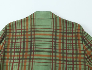 Detailed close-up of retro plaid pattern collar and textured woven fabric on the blazer