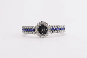 Details der silbernen Damenarmbanduhr mit blauen Edelsteinen und Sonnenblumen-Zifferblatt