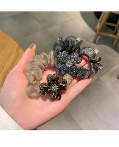 Close-up of organza scrunchies with large rhinestone four-leaf clover flower decorations