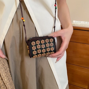 Detailed close-up of handmade woven mini crossbody bag with yellow floral beads in ethnic style