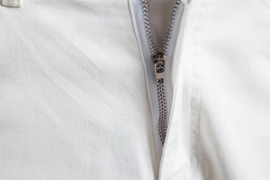 Détail de la fermeture éclair en métal et coutures sur le short en coton blanc