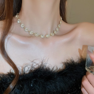 Gros plan d'un collier doré étincelant avec grappes de cristaux sur le cou du mannequin
