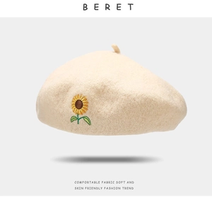 Detailed close-up of sunflower embroidery on a beige wool beret hat for women