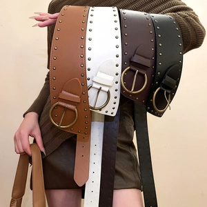 Macro detail of wide vintage PU leather belts with bronze studs and round metal buckles