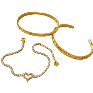 Dreiteiliges goldenes Edelstahl-Schmuckset mit Herzarmband und strukturierten Armreifen