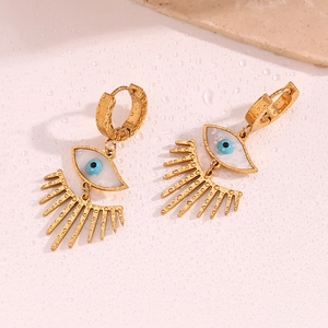 Détail de boucles d'oreilles Evil Eye plaquées or 18 carats sur fond rose à gouttes d'eau