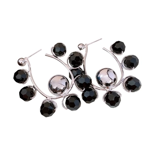 Modern C-shaped hoop earrings with silver metal and multifaceted black beads on white base