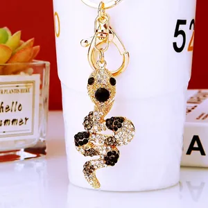 Macro shot of a gold-plated snake keychain inlaid with sparkling white and black rhinestones