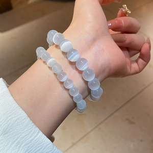 Close-up of layered grey cat eye stone beaded bracelets showing optical chatoyancy effect