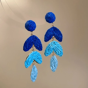 Detailed close-up of blue gradient raffia tassel earrings with handcrafted woven texture
