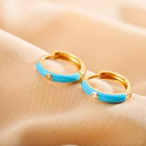Macro shot of gold-plated hoop earrings with sky blue enamel and small zircon stone
