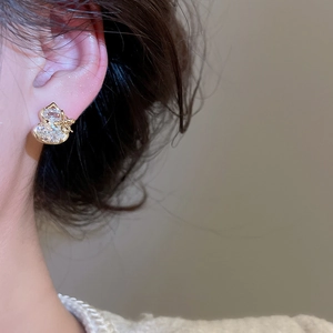 Detail of gold-plated gourd stud earring with sparkling cubic zirconia on a model