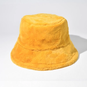 Close-up of bright yellow faux fur bucket hat showing thick plush texture for winter warmth