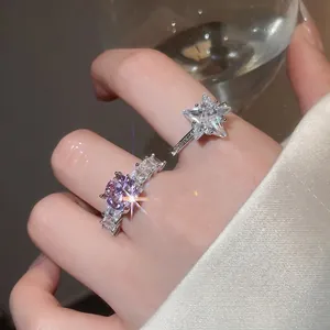 Elegant silver stackable rings featuring lavender gemstone and zircon star on model hand