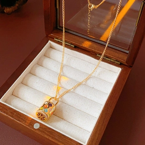 Detail of vintage enamel necklace with a colorful floral pendant inside a luxury wooden box
