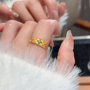 Close-up of retro 24k gold plated ring with green zircon flower and brushed texture metal