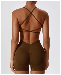 Detail of dark brown criss-cross back sports bra and scrunch butt gym shorts on model