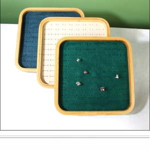 Detail of bamboo jewelry tray with green velvet slots for rings and earrings