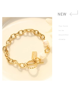 Macro detail of gold chunky chain bracelet with freshwater pearls and T-bar OT closure