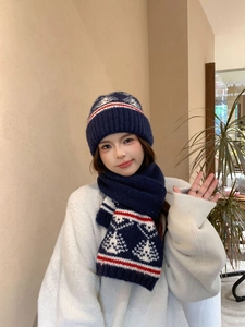 Dettaglio del set cappello e sciarpa in maglia Fair Isle blu navy su una modella femminile