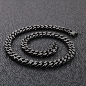 Close-up of black stainless steel Cuban link necklace with clasp on leather background