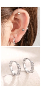 Detail of silver wavy hoop earrings with three zircon stones shown on ear and stone base